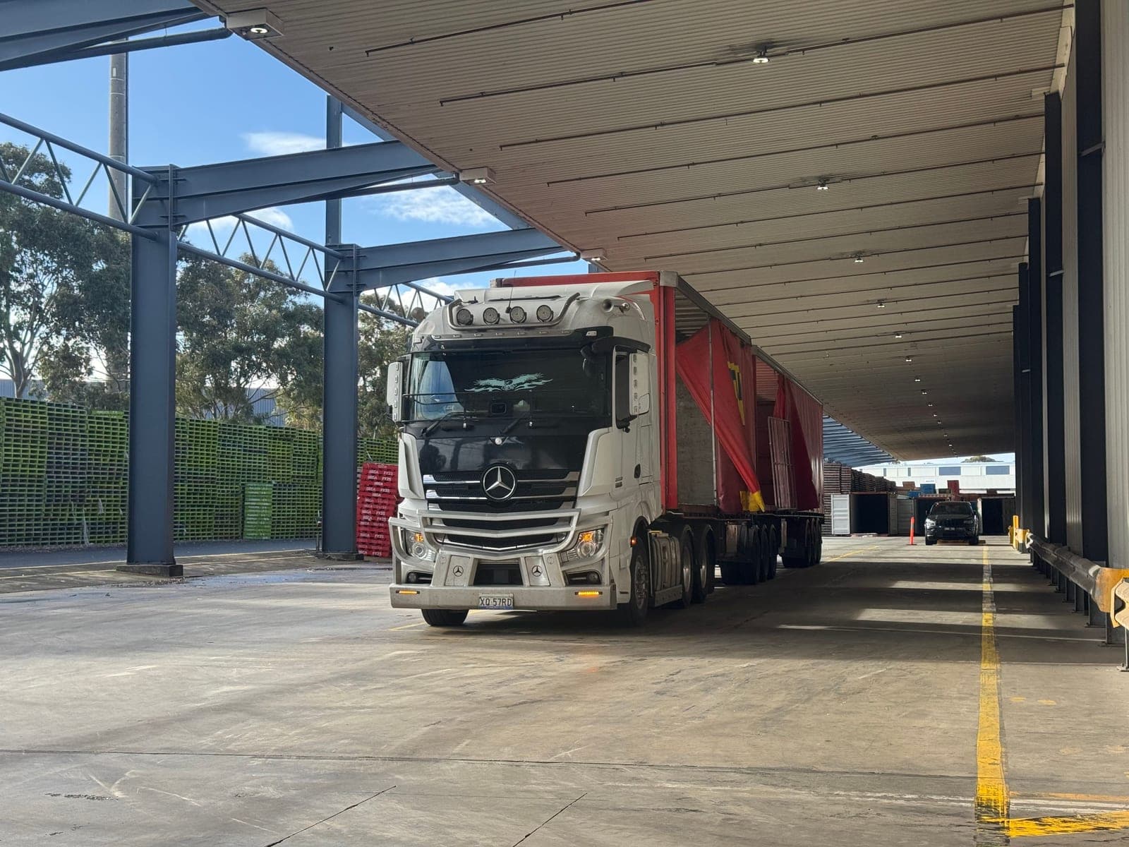 Tracteur Mercedes et remorque à rideaux rouges au quai de chargement, formation capacité marchandises +3,5 t